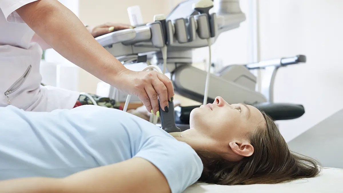 Physician performing a thyroid ultrasound